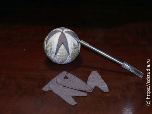 Заправляем ткань в прорези на шаре тупой стороной лезвия макетного ножа