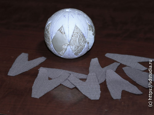 Заправляем ткань в прорези на шаре тупой стороной лезвия макетного ножа